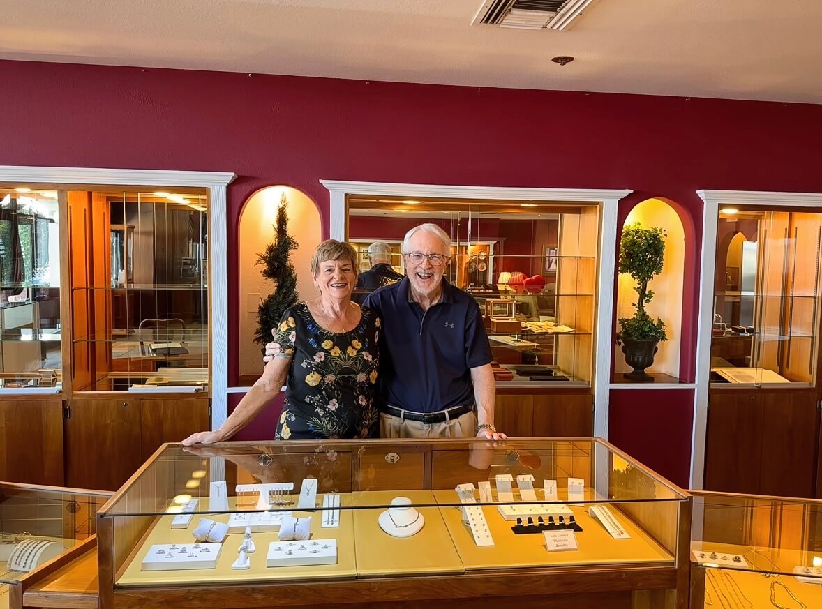 Geoff and Jody Woerner, owners of Cranstoun Court Jewellers, standing behind the jewelry display cases in their Sun City West store